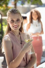 Fototapeta na wymiar Smiling woman holding glass of wine in restaurant