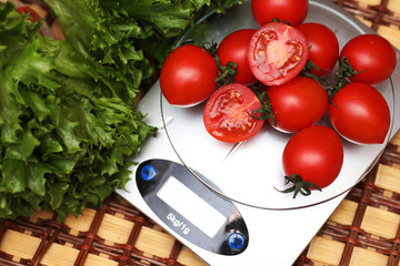 Fresh tomatoes on kitchen scales weighing