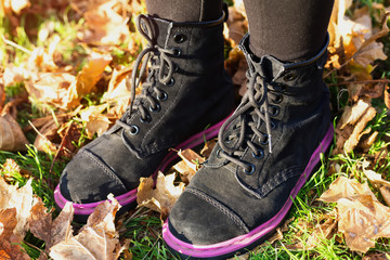 Walking through the autumn leaves, closeup.Feet sneakers walking on fall leaves in park with Autumn season nature on background Lifestyle Fashion trendy style