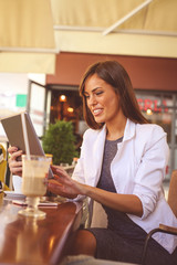 Young business woman working in cafe with digital tablet. Girl in cafe.