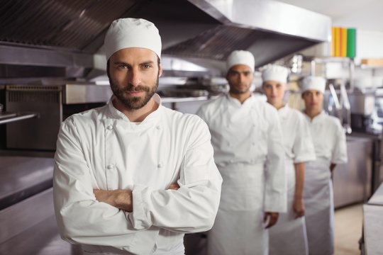 Happy chefs team standing together in commercial kitchen
