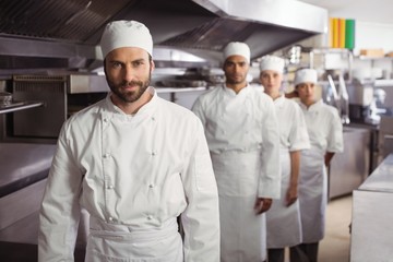 Happy chefs team standing together in commercial kitchen