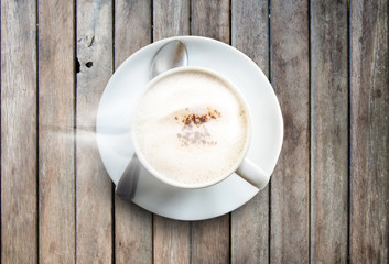 Cup of coffee and smoke on wooden desk table background.