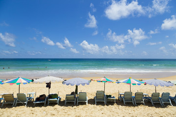 Beach chairs with sea scenery and people swimming joyful