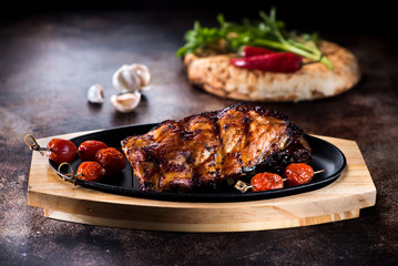 Grilled pork BBQ ribs serving on a cast-iron frying pan