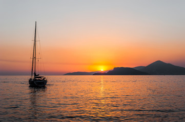 Tranquil nature scene of sailing boat in the ocean at sunset 