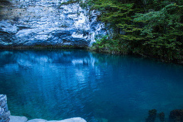 Amazing view of blue mountain lake like paradise, rock wall and colorful water .Scenery of Abkhazia paradise nature with awesome closeup perspective and fast stream.
