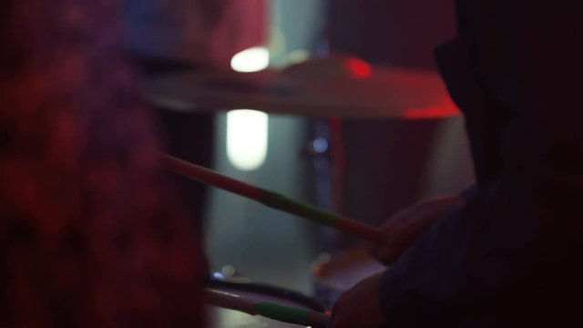  Live band performing for young nightclub crowd, close up on drummer