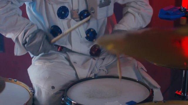  Close up on drum kit, drummer dressed as astronaut playing in a band