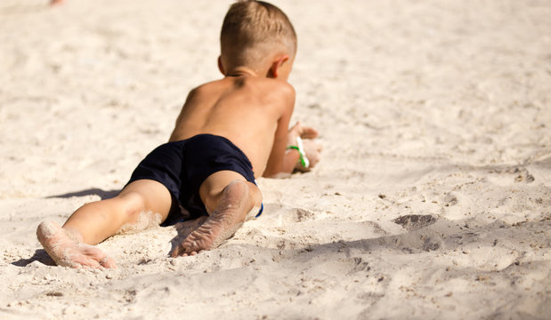 Feet of a boy playing in the sand