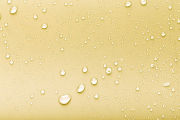 Drops of water on a color background. Yellow. Toned
