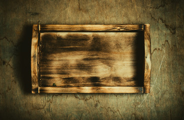 Handmade burned box on a wooden rustic texture for background. Rough weathered wooden board. Toned
