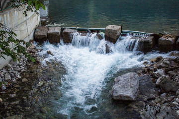 A stream from a waterfall in the mountains runs through the rocks
