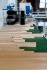 Pile of wood on electric brush machine in factory shavings and polishing timber.