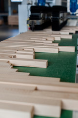 Pile of wood on electric brush machine in factory shavings and polishing timber.