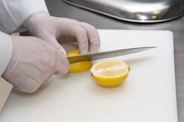 Fresh lemon on a white cutting board of restaurant kitchen. Selective focus. Shallow depth of field