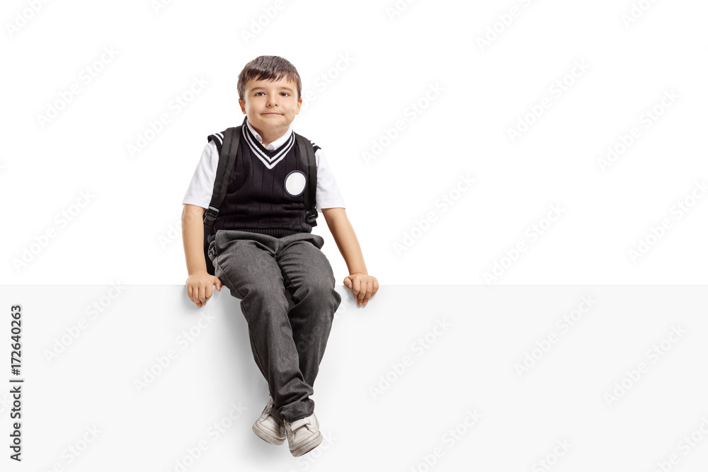 Poster Schoolboy seated on a panel looking at the camera