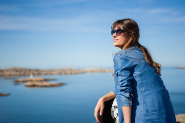 Young woman sitting by sea and relaxing 