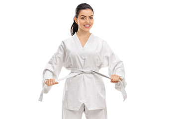Young woman dressed in a kimono tying a white belt