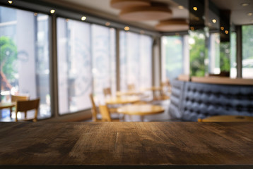 Empty dark wooden table in front of abstract blurred background of coffee shop . can be used for display or montage your products.Mock up for display of product