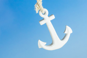 A white anchor with a bright blue sky as background