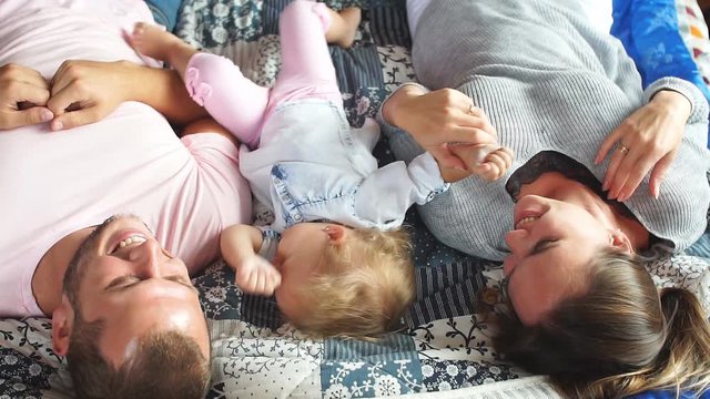 Family playing together in bedroom in slow motion.