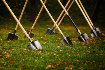 series of shovels stuck into the ground lawn.