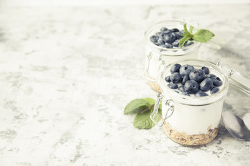 Fototapeta na wymiar Granola with yougurt, mint and berries in jars. Toned.
