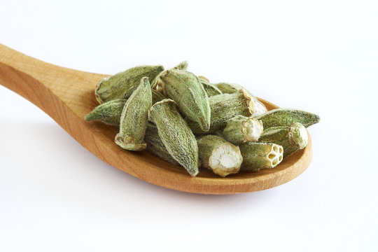 Dried okra (ladies' fingers, ochro) in wooden spoon isolated on white background