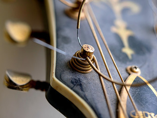 ropes of an old folk guitar with gold machine head