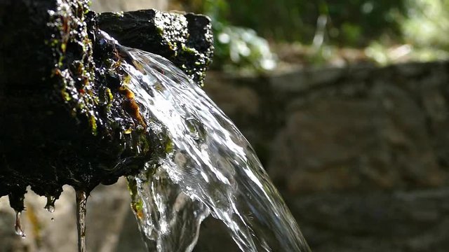 Close-up of the spout of a mountain fountain with crystalline, pure and bright water.Low angle.Slow Motion.