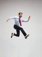 Businessman running on gray background