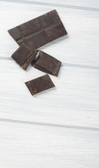 Chocolate bar on wooden table. Copy space. Copy space. Vertical studio shoot.
