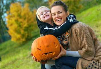 mother and daughter with Halloween pumpkin Jack O’Lantern