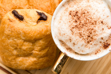 Light morning breakfast with croissant and coffee