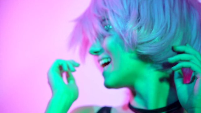 Disco girl dancing on party. Young model woman in colorful bright lights with trendy makeup and haircut. Slow motion 240 fps. 4K UHD video 3840x2160