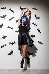 Emotional happy young woman in witch halloween costume