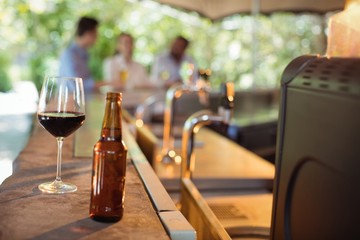 Wine glass and beer bottle at counter