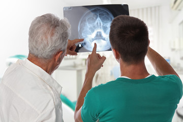 Obraz premium Male doctor dentist looking at x-ray of patient