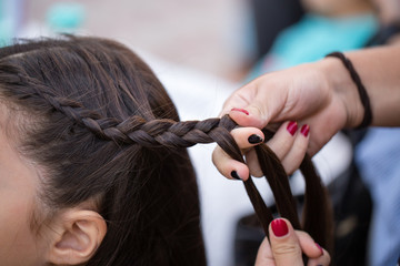 the stylist weaves the female braids on the head