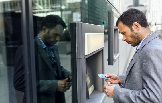 Businessman taking money at an ATM in the city