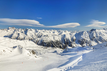 Panoramic landscape of ski resort valley with amazing beautiful mountains and dramatic cloudy sky on the background in Austria