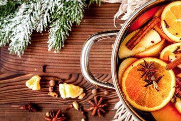 preparation of mulled wine in pot wooden background top view