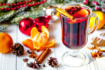 Christmas mulled wine with spices in cup on wooden background