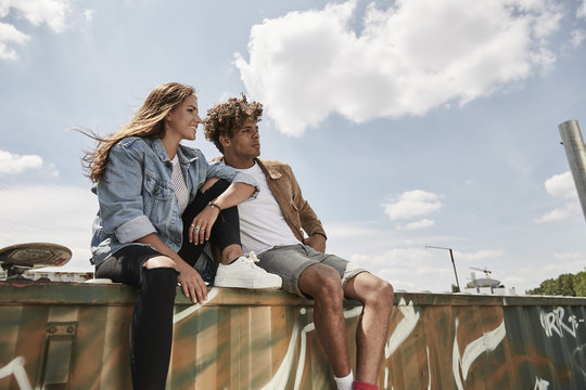 Young couple sitting on a wall