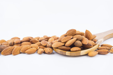 Almonds nuts in wooden ladle isolated on white background. Tasty medicine from nature.