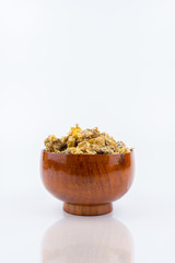 Dried yellow Chrysanthemum and wooden bowl isolated on white background - Chrysanthemum tea is traditional Asian Chinese remedy to improve eyesight and clear liver heat.