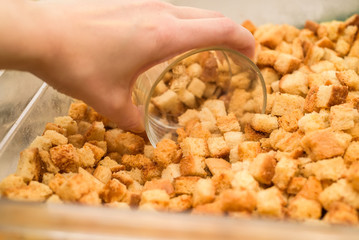 Scooping home made croutons in glass