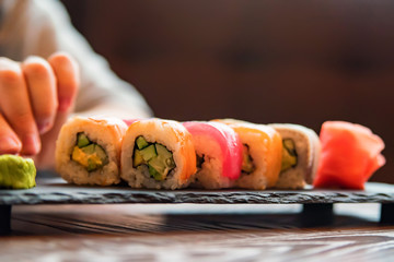 Eating sushi rainbow roll in restaurant