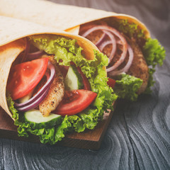 pair of fresh juicy wrap sandwiches with chicken and vegetables